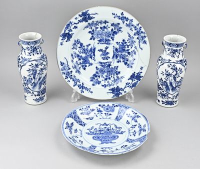 une assiette bleue et blanche, des vases et une assiette posés sur une table
