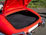 a red car with its trunk open on the street