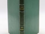 an old book with a green cover sitting on top of a white table