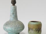 une paire de vases en céramique portant des inscriptions et un petit vase avec une bougie
