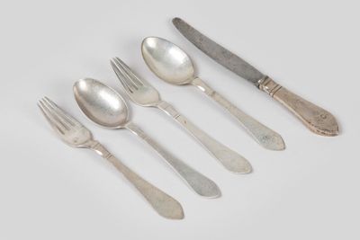 six cuillères, fourchettes et un couteau posés sur un plateau blanc