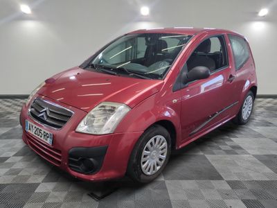 la petite voiture rouge est garée sur un sol en damier
