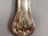 a silver spoon that is on a white surface