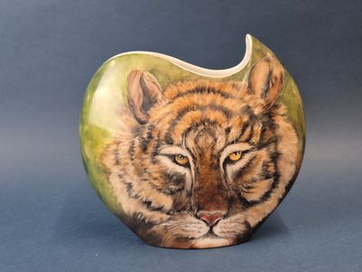 une pomme en forme de tigre sur laquelle est dessiné un visage
