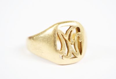 a close up of a gold ring with a monogram on it