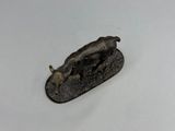 une petite statue représentant un taureau posée sur une surface blanche