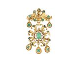 un gros plan sur une broche en or et turquoise