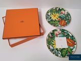 une boîte orange et deux assiettes ornées de fleurs, posées sur une table