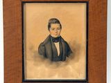 portrait d'un homme en costume et nœud papillon, dans un cadre en bois