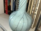 un vase posé sur une étagère à côté de quelques livres