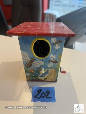 un petit nichoir au toit rouge posé sur une table