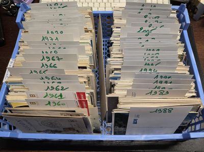 de nombreuses piles de papiers dans un panier bleu posé sur une table