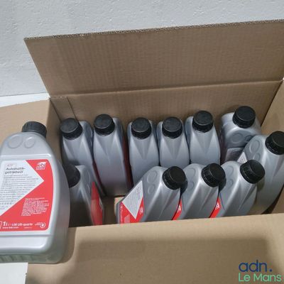 plusieurs bouteilles d'huile moteur dans un carton