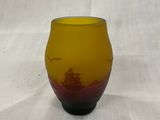 un vase en verre jaune et rouge posé sur une table blanche
