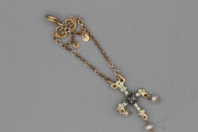 un gros plan d'un collier avec une croix suspendue à une chaîne