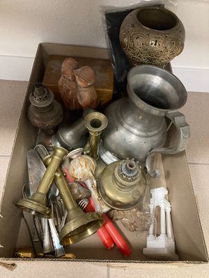 une boîte remplie de vieux objets posée par terre