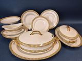 un service de vaisselle en porcelaine blanche et dorée, orné de bordures dorées