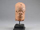 an image of a clay head on a stand on a gray background