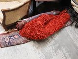 un tapis rouge posé par terre, à côté d'une chaise et d'une table
