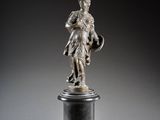 une statue en argent représentant un homme tenant un bouclier et un bouclier