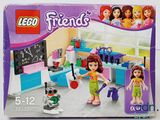 une boîte contenant un ensemble Lego Friends avec une petite fille et un chien