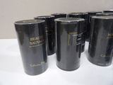several black cans of coffee are lined up on a white table