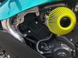 a close up of a motorcycle engine with a yellow air filter