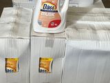 une bouteille de détergent posée sur une pile de cartons