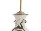 a white vase with a dragon on it and a gold cup on top