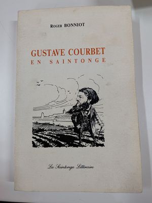 un vieux livre posé sur une table blanche à côté d'une tasse