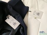 a white shirt and a black jacket with a tag on it