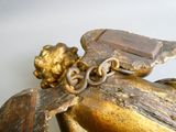 a gold statue of a man on a horse with a chain around his neck