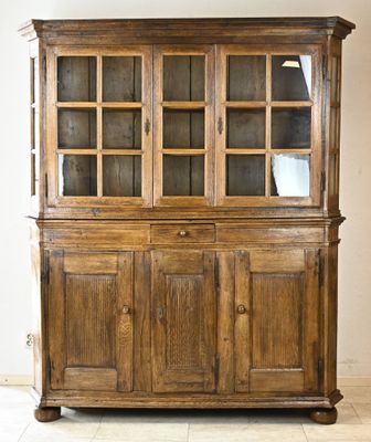 une grande armoire en bois avec des portes vitrées