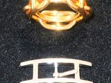 une bague en or et une bague en argent posées sur une surface noire