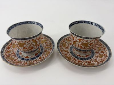 deux tasses et soucoupes sont posées sur une surface blanche