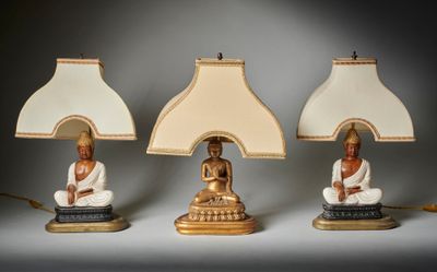 trois lampes ornées de statues de Bouddha, posées sur une table