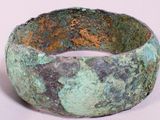 a close up of a green bracelet on a white surface