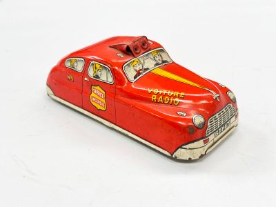 une petite voiture rouge posée sur une surface blanche