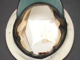 a white hat with a green visor sitting on top of a white plate
