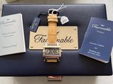 a suitcase with a watch and a book on top of it