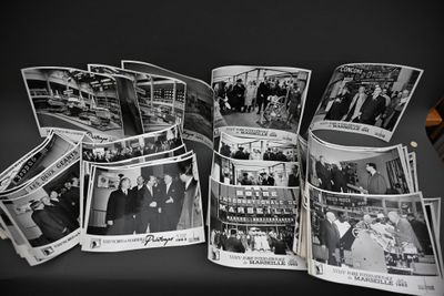 plusieurs photos en noir et blanc montrant un groupe de personnes assises à une table