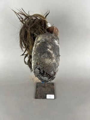 une sculpture représentant une tête de chien sur laquelle se trouve un poil