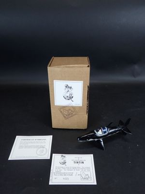 un petit avion miniature posé à côté d'une boîte