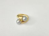 a close up of a gold ring with two pearls on it