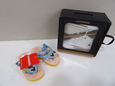 une paire de chaussures de bébé et une boîte posées sur une table