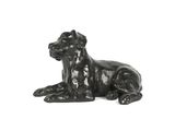 une statue représentant un chien couché sur une surface blanche