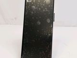 the back of a black cell phone sitting on top of a white table
