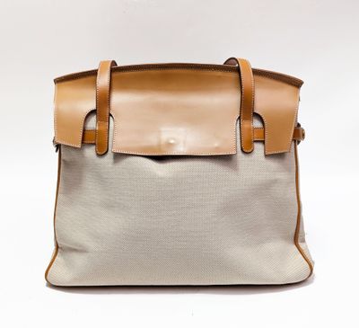 une photo d'un sac à main blanc et beige muni de anses en cuir