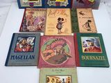 several children ' s books are lined up on a white surface