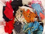 a basket full of clothes that is on a bed